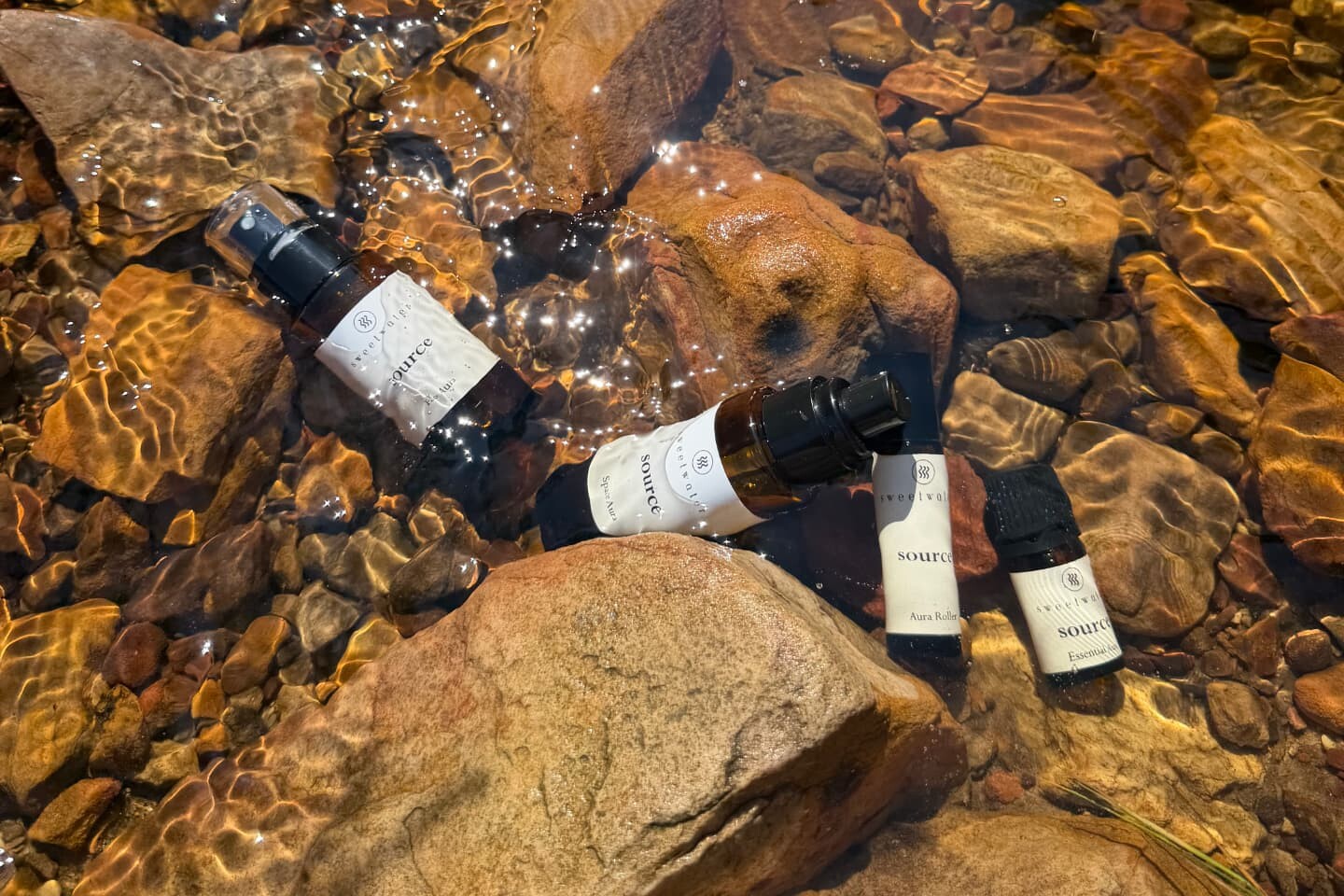 Source bottles and vessels resting in the shallows of a mountain stream