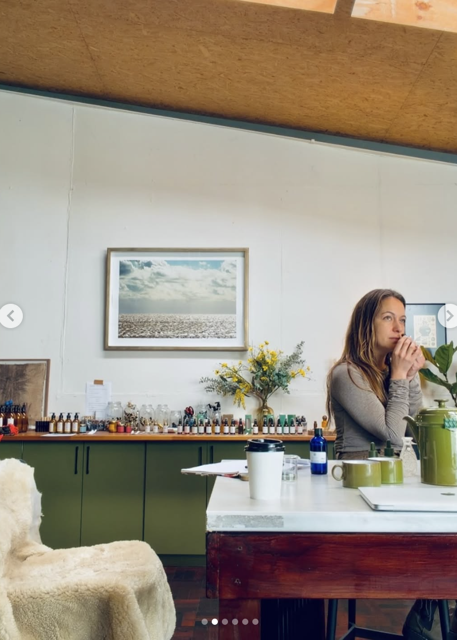 A perfume studio with botanical oils, bottles and natural materials arranged on a green counter